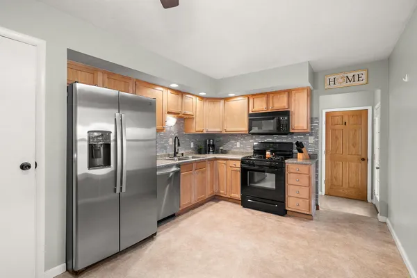 a kitchen with stainless steel appliances granite countertop a refrigerator and a stove top oven
