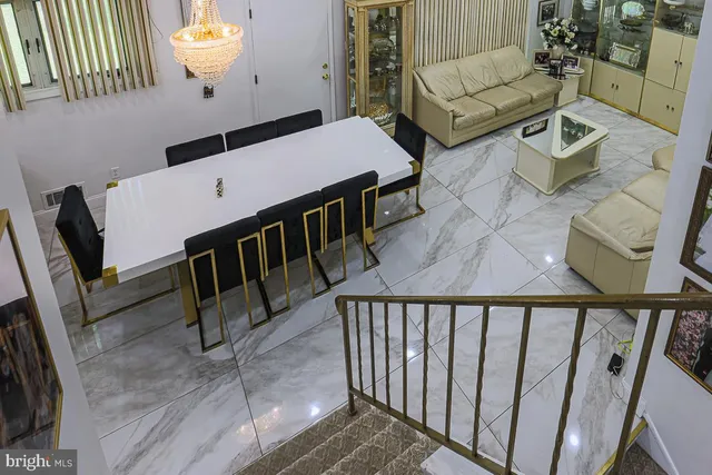 a living room with couches and a dining table with wooden floor