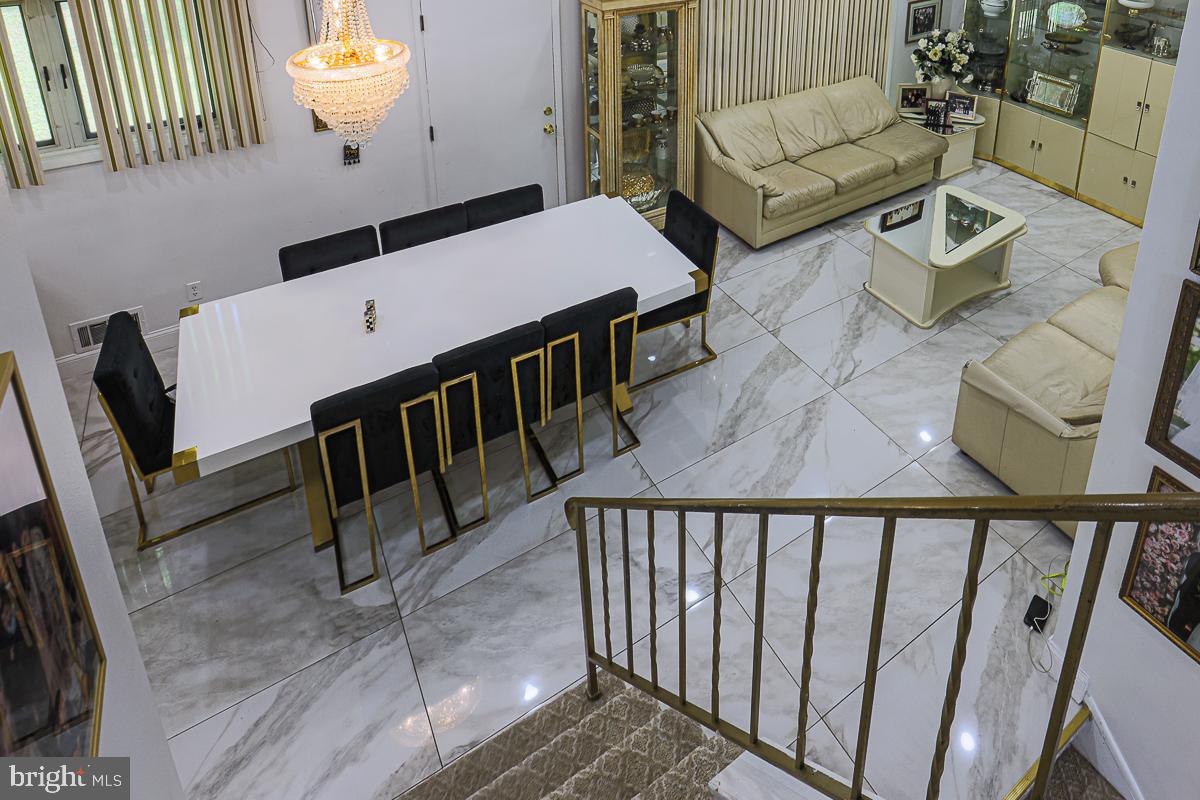 3111 Parkington Avenue Baltimore, MD 21215 - Photo 15 of 47 a living room with couches and a dining table with wooden floor