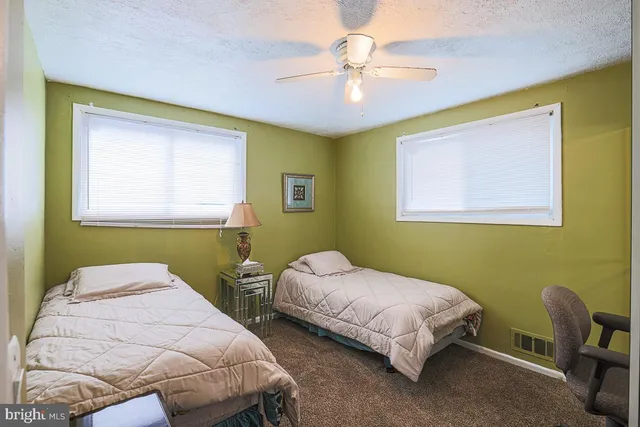 a bedroom with 2 bed and a chair