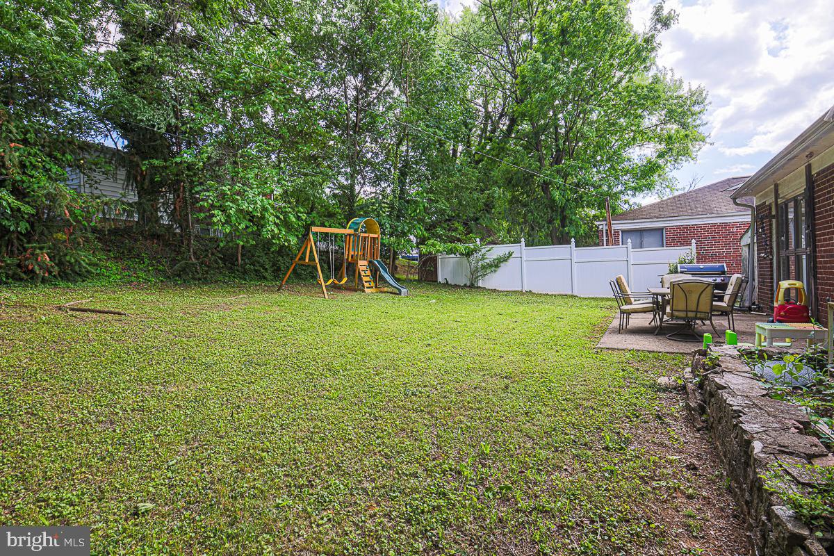 3111 Parkington Avenue Baltimore, MD 21215 - Photo 35 of 47 a view of a backyard with table and chairs a barbeque and fence