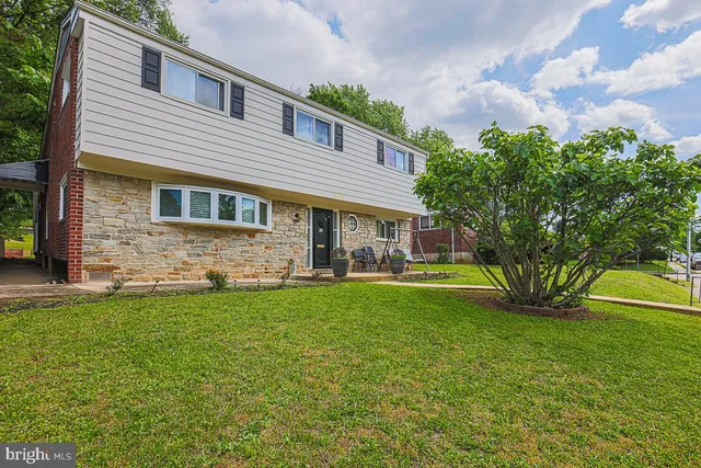a view of a house with a yard and sitting area