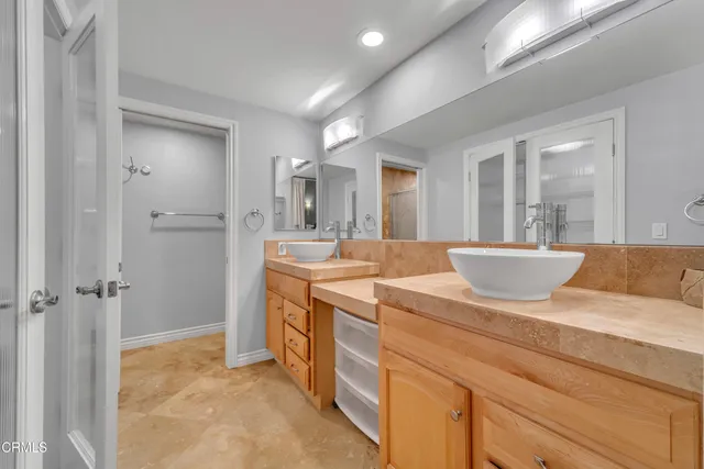 a spacious bathroom with a granite countertop sink a mirror and a shower