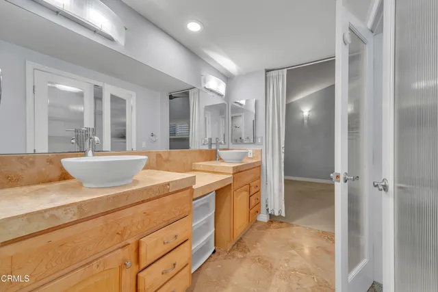 a spacious bathroom with a shower sink and mirror