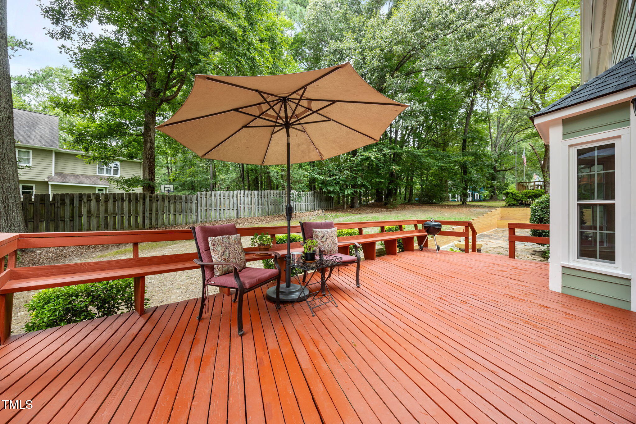 8009 Running Cedar Trail Raleigh, NC 27615 - Photo 37 of 42 a view of a roof deck with table and chairs under an umbrella with wooden floor and fence