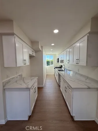 a large kitchen with stainless steel appliances kitchen island granite countertop a sink and cabinets