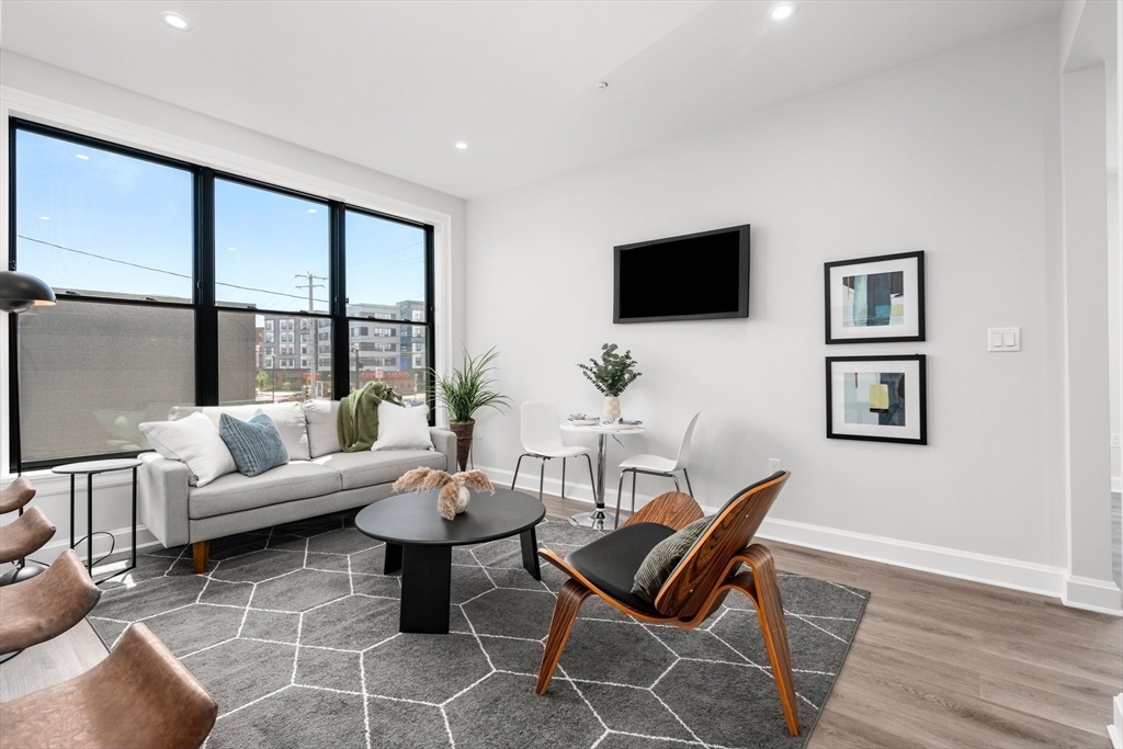 523 2nd Street, Unit 303 Everett, MA 02149 - Photo 4 of 11 a living room with furniture a flat screen tv and a large window