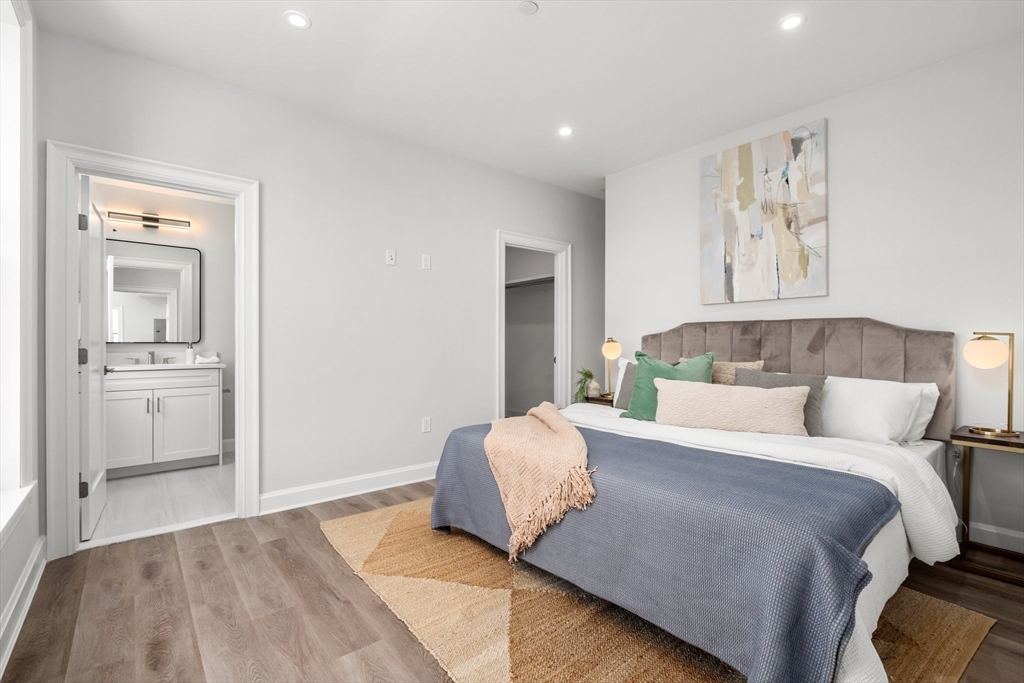 523 2nd Street, Unit 303 Everett, MA 02149 - Photo 6 of 11 a bedroom with a large bed and ceiling fan