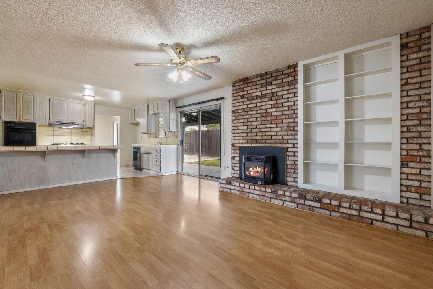 1205 Kara Lane Modesto, CA 95355 - Photo 11 of 39 a view of an empty room with a fireplace and a window