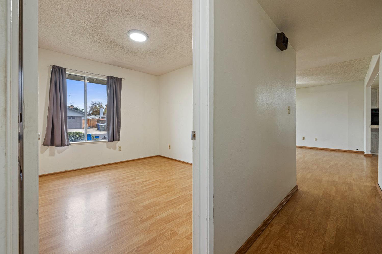 1205 Kara Lane Modesto, CA 95355 - Photo 20 of 39 a view of an empty room with wooden floor and a window