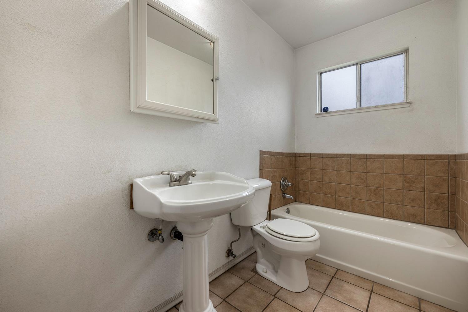 1205 Kara Lane Modesto, CA 95355 - Photo 32 of 39 a bathroom with a sink a toilet and a bathtub