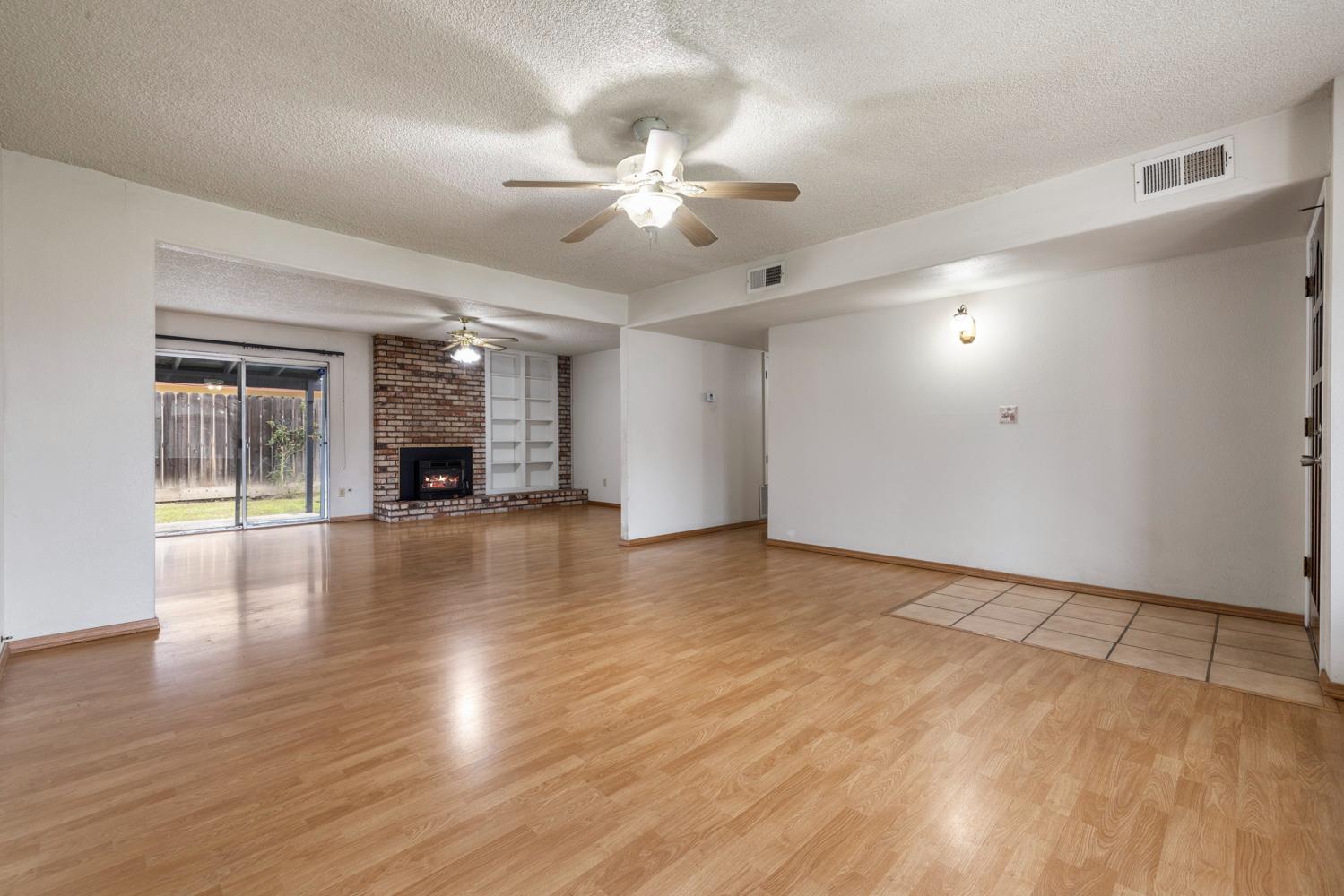 1205 Kara Lane Modesto, CA 95355 - Photo 9 of 39 a view of empty room with wooden floor and fan