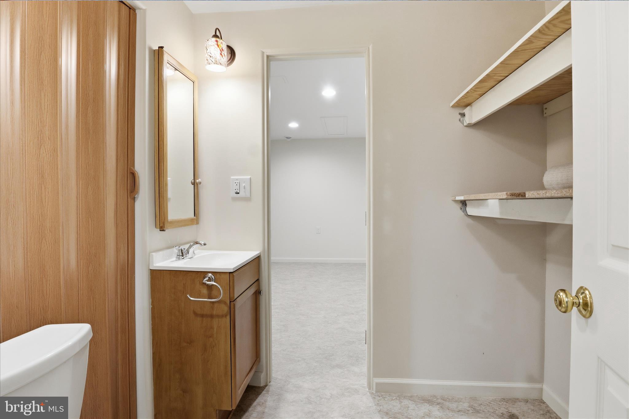 6809 Spout Lane Fairfax Station, VA 22039 - Photo 43 of 81 a bathroom with a granite countertop sink a mirror and a toilet