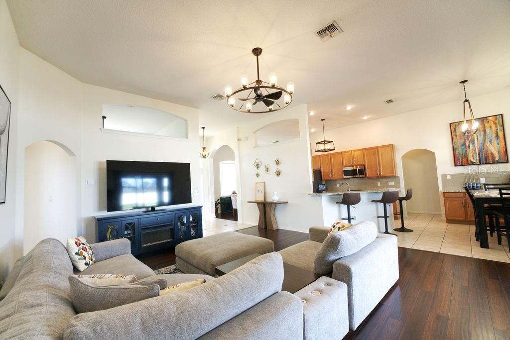 2309 Wolf Ridge Lane Mount Dora, FL 32757 - Photo 12 of 62 a living room with furniture a flat screen tv and kitchen view