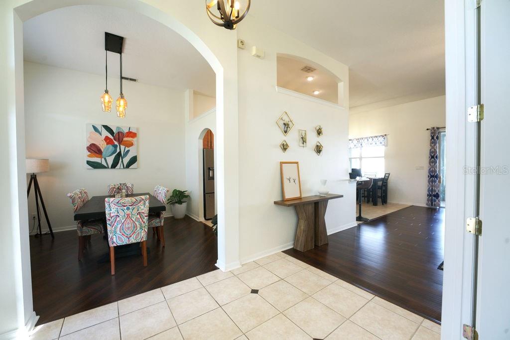 2309 Wolf Ridge Lane Mount Dora, FL 32757 - Photo 13 of 62 a hallway with a dining table and a chandelier