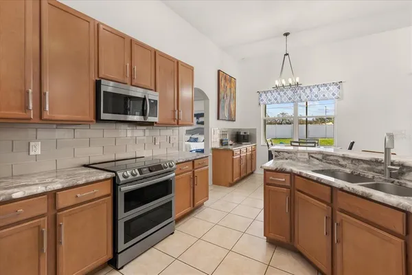 a kitchen with stainless steel appliances granite countertop a stove a sink and a microwave