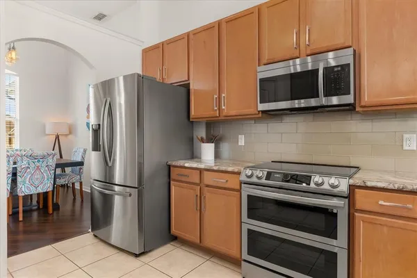a kitchen with granite countertop a refrigerator stove and microwave