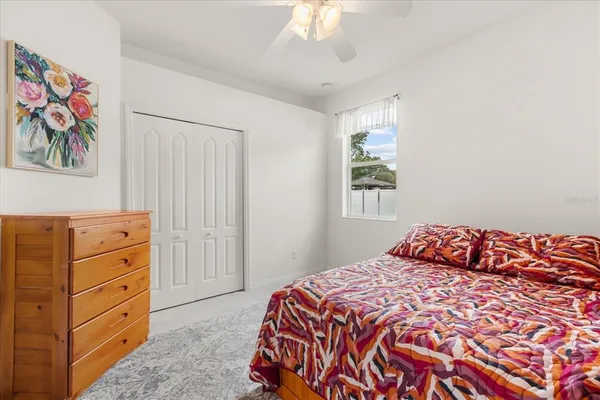 a bedroom with a bed and painting on the wall