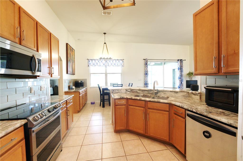 2309 Wolf Ridge Lane Mount Dora, FL 32757 - Photo 16 of 62 a large kitchen with a large window and stainless steel appliances