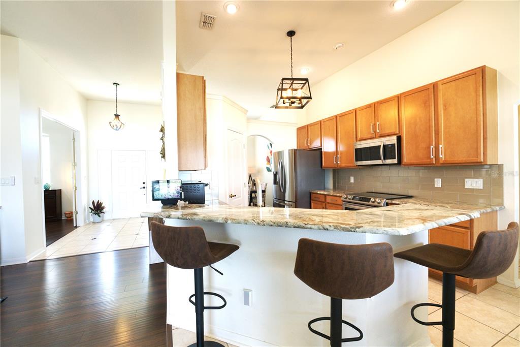 2309 Wolf Ridge Lane Mount Dora, FL 32757 - Photo 17 of 62 a kitchen with stainless steel appliances granite countertop a stove a sink and cabinets