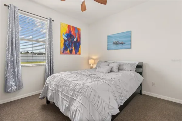 a bedroom with bed and wall painting with wooden floor