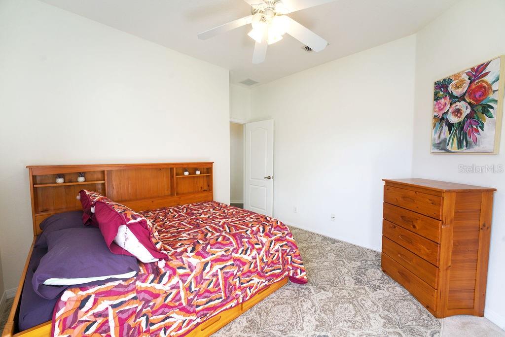 2309 Wolf Ridge Lane Mount Dora, FL 32757 - Photo 30 of 62 a bedroom with a bed and a chandelier