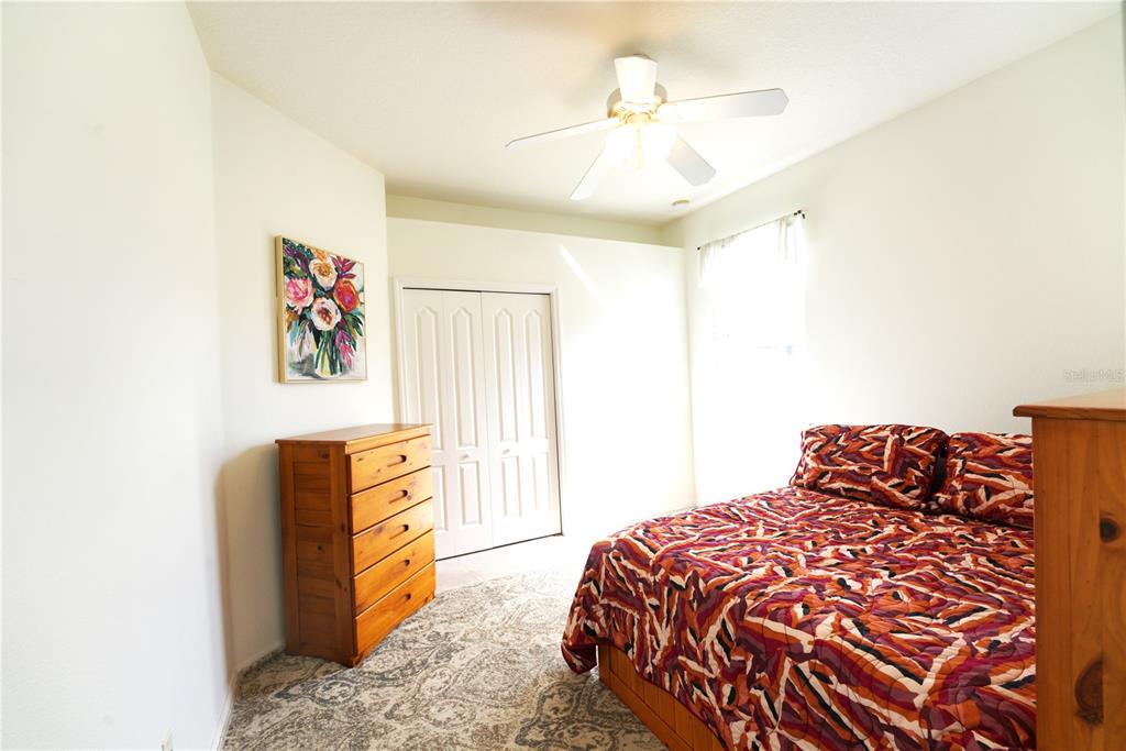 2309 Wolf Ridge Lane Mount Dora, FL 32757 - Photo 32 of 62 a bedroom with a bed and a chandelier