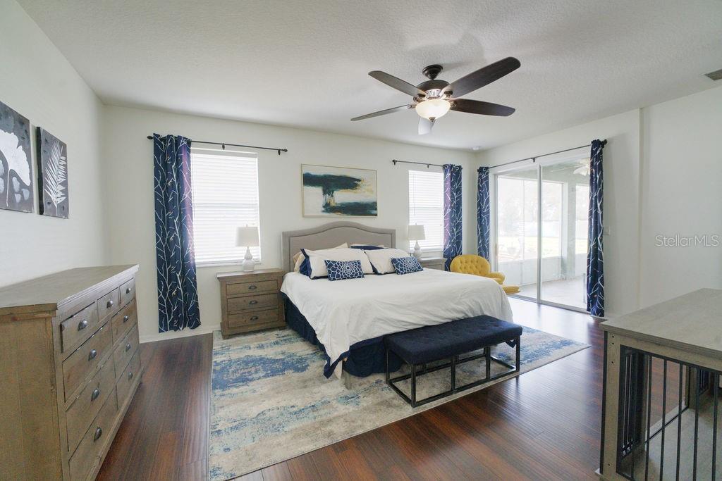 2309 Wolf Ridge Lane Mount Dora, FL 32757 - Photo 38 of 62 a spacious bedroom with a bed and a chandelier