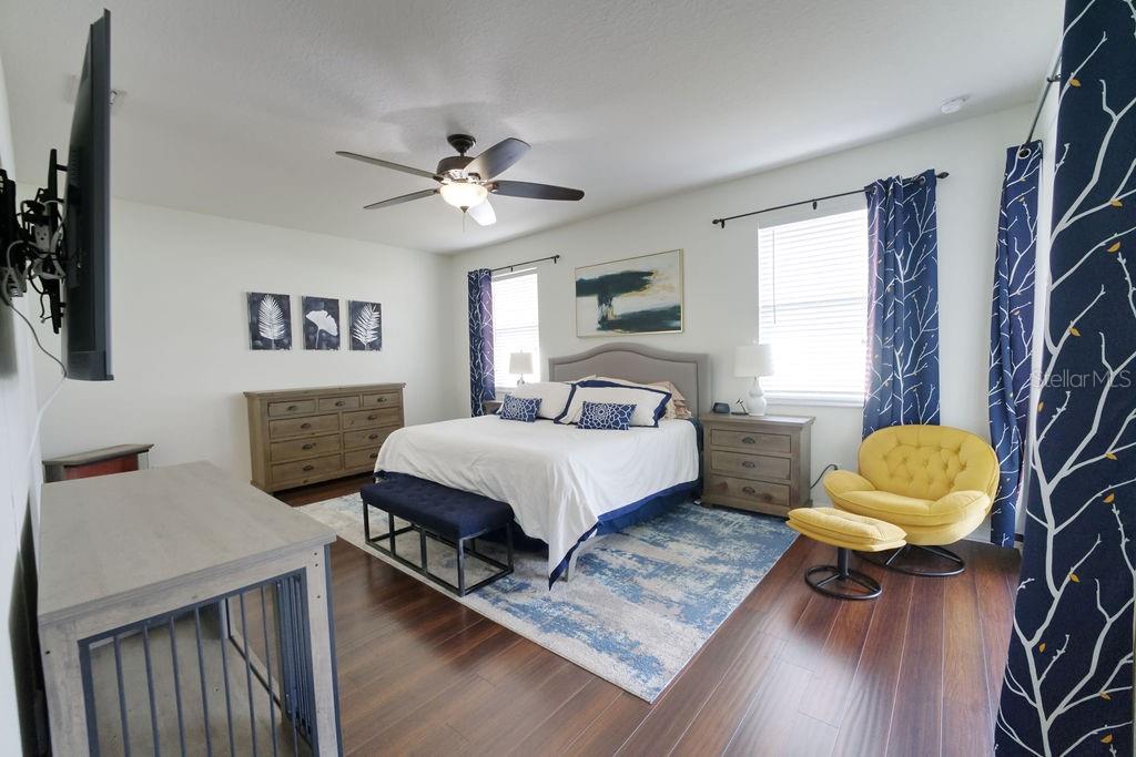 2309 Wolf Ridge Lane Mount Dora, FL 32757 - Photo 39 of 62 a bedroom with a bed a couch and a chandelier