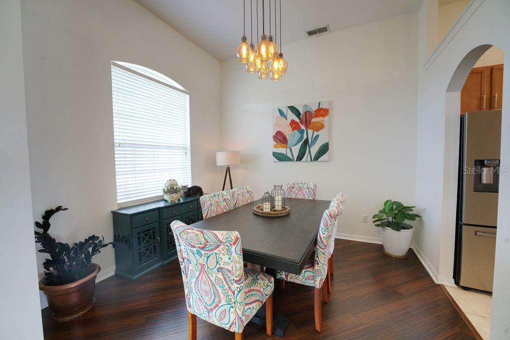 2309 Wolf Ridge Lane Mount Dora, FL 32757 - Photo 5 of 62 a dining room with furniture potted plants and wooden floor