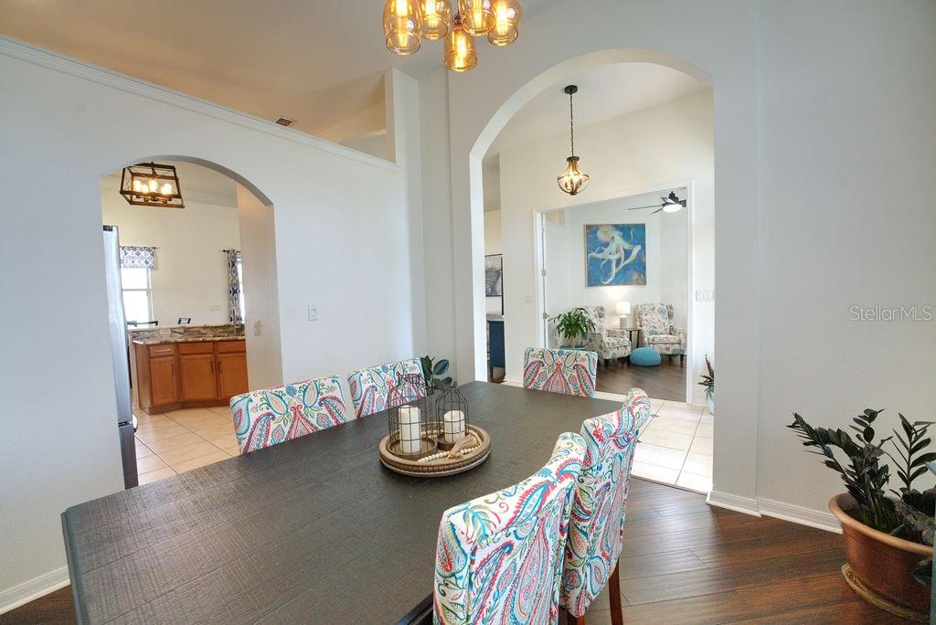 2309 Wolf Ridge Lane Mount Dora, FL 32757 - Photo 7 of 62 a view of a dining room with furniture and wooden floor
