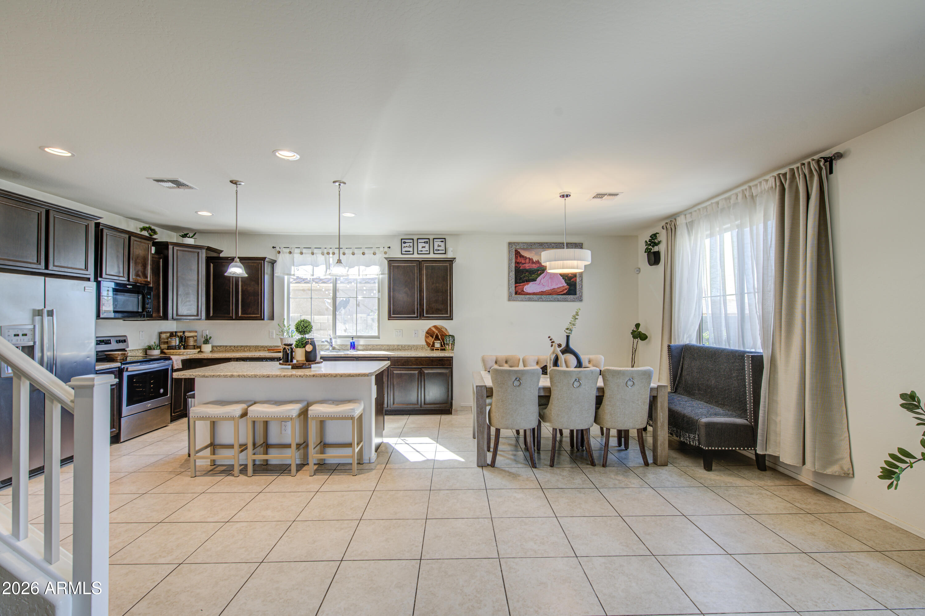 12202 West Del Rio Lane Avondale, AZ 85323 - Photo 11 of 49 a living room with furniture a flat screen tv and kitchen view