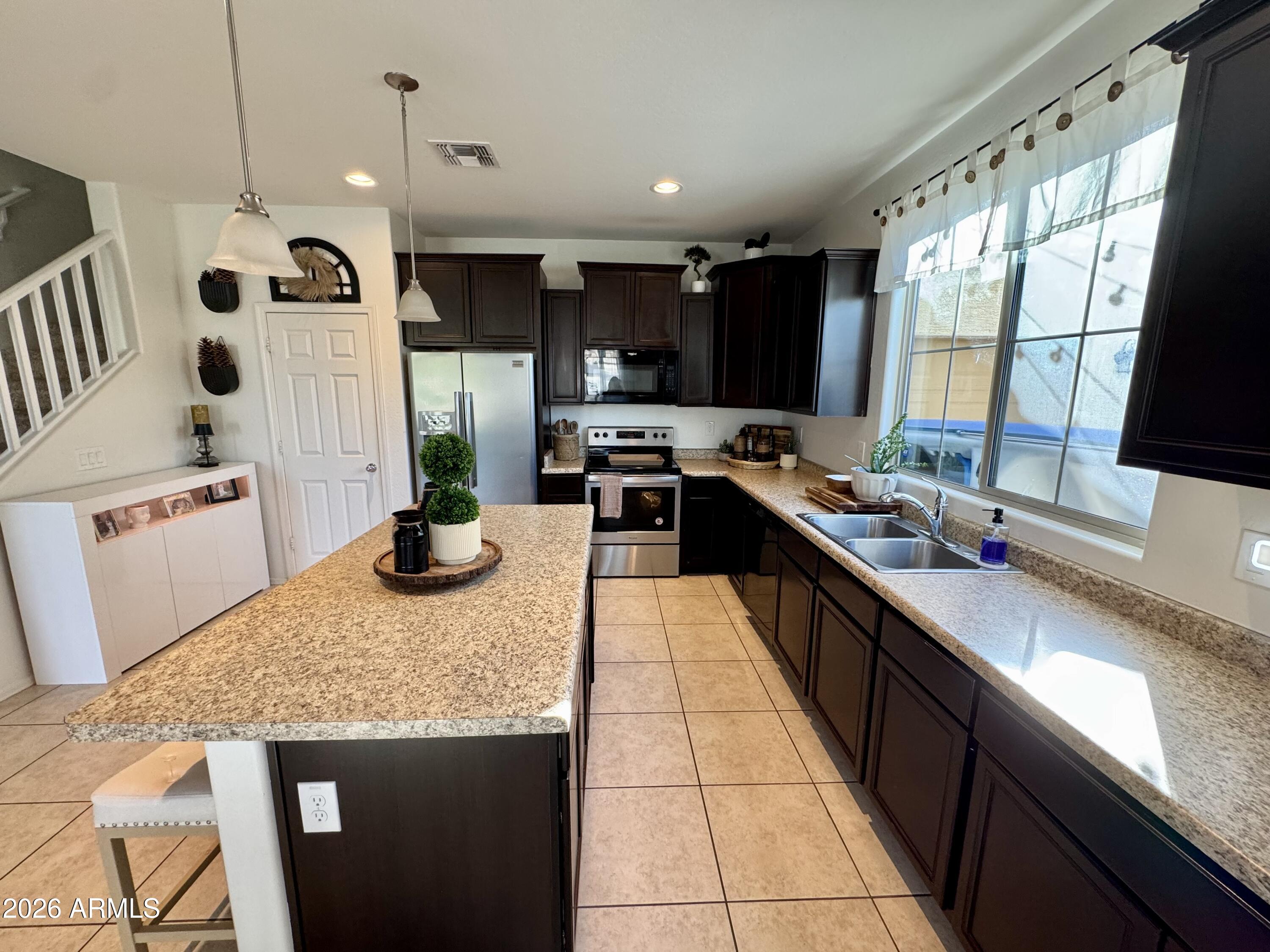 12202 West Del Rio Lane Avondale, AZ 85323 - Photo 11 of 60 a kitchen with stainless steel appliances granite countertop a sink stove and refrigerator