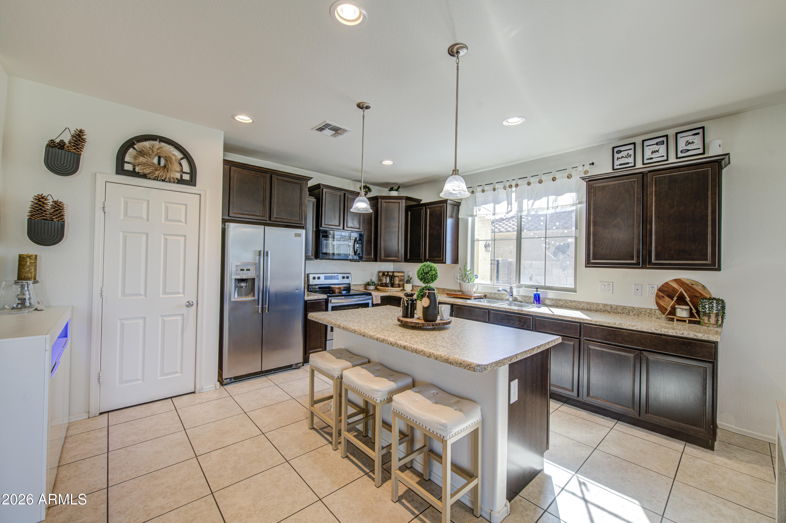 12202 West Del Rio Lane Avondale, AZ 85323 - Photo 12 of 49 a kitchen with stainless steel appliances granite countertop a sink and a refrigerator