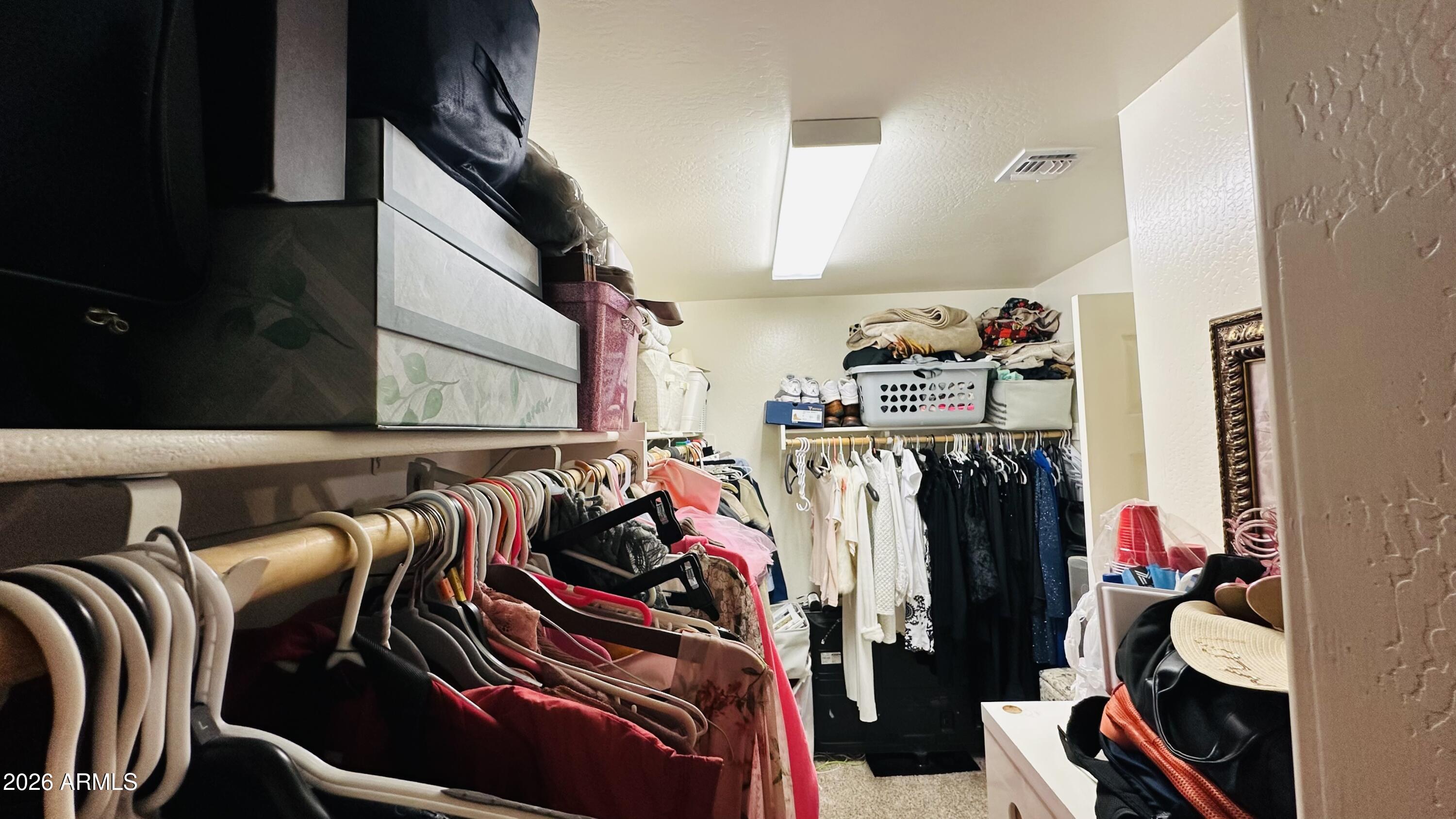 12202 West Del Rio Lane Avondale, AZ 85323 - Photo 39 of 60 a view of walk in closet with clothes and shoes