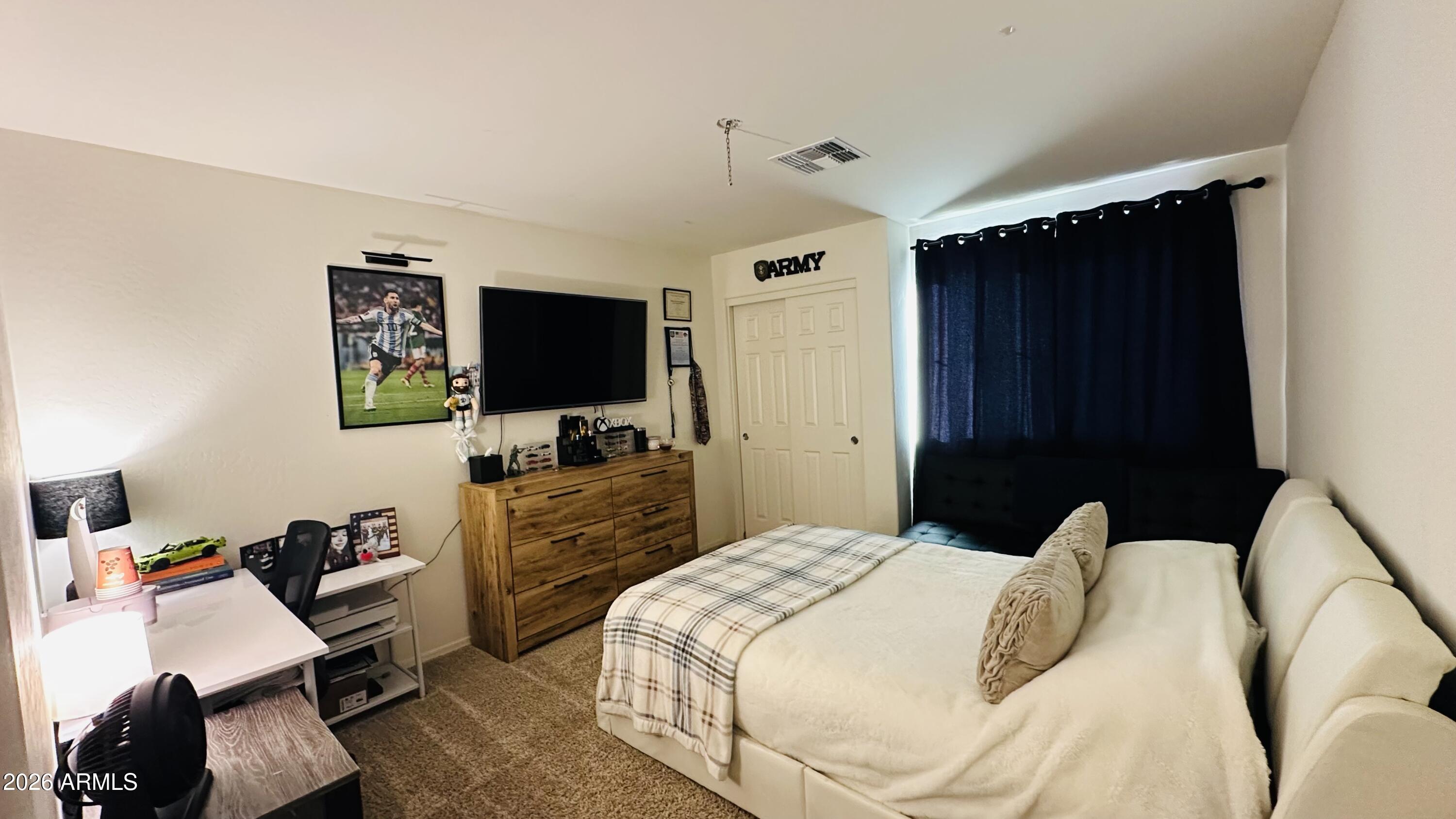 12202 West Del Rio Lane Avondale, AZ 85323 - Photo 46 of 60 a bedroom with a bed and a flat tv screen on dresser
