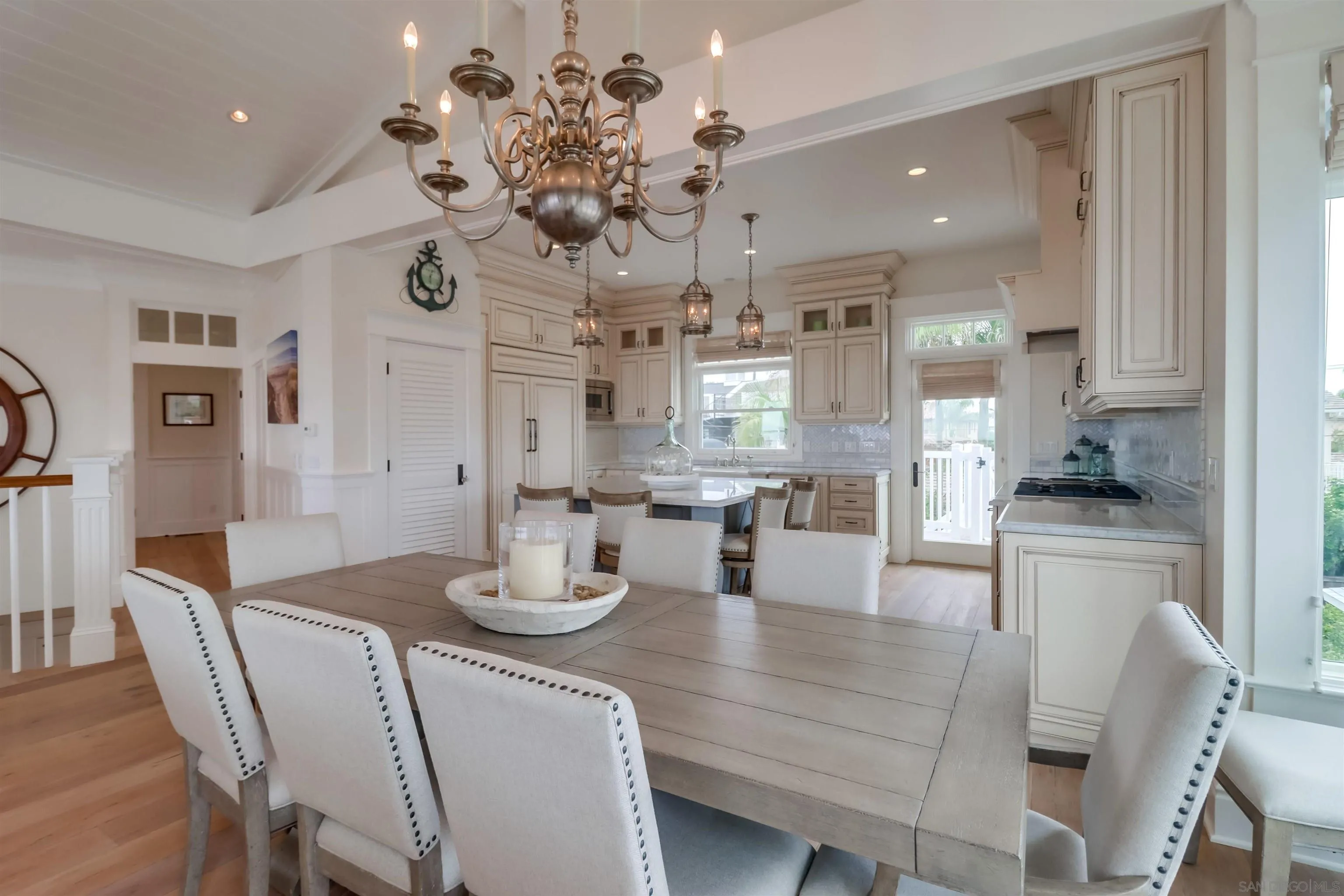 441 Ocean Boulevard Coronado, CA 92118 - Photo 7 of 40 a dining room with wooden floor a chandelier a wooden table and chairs