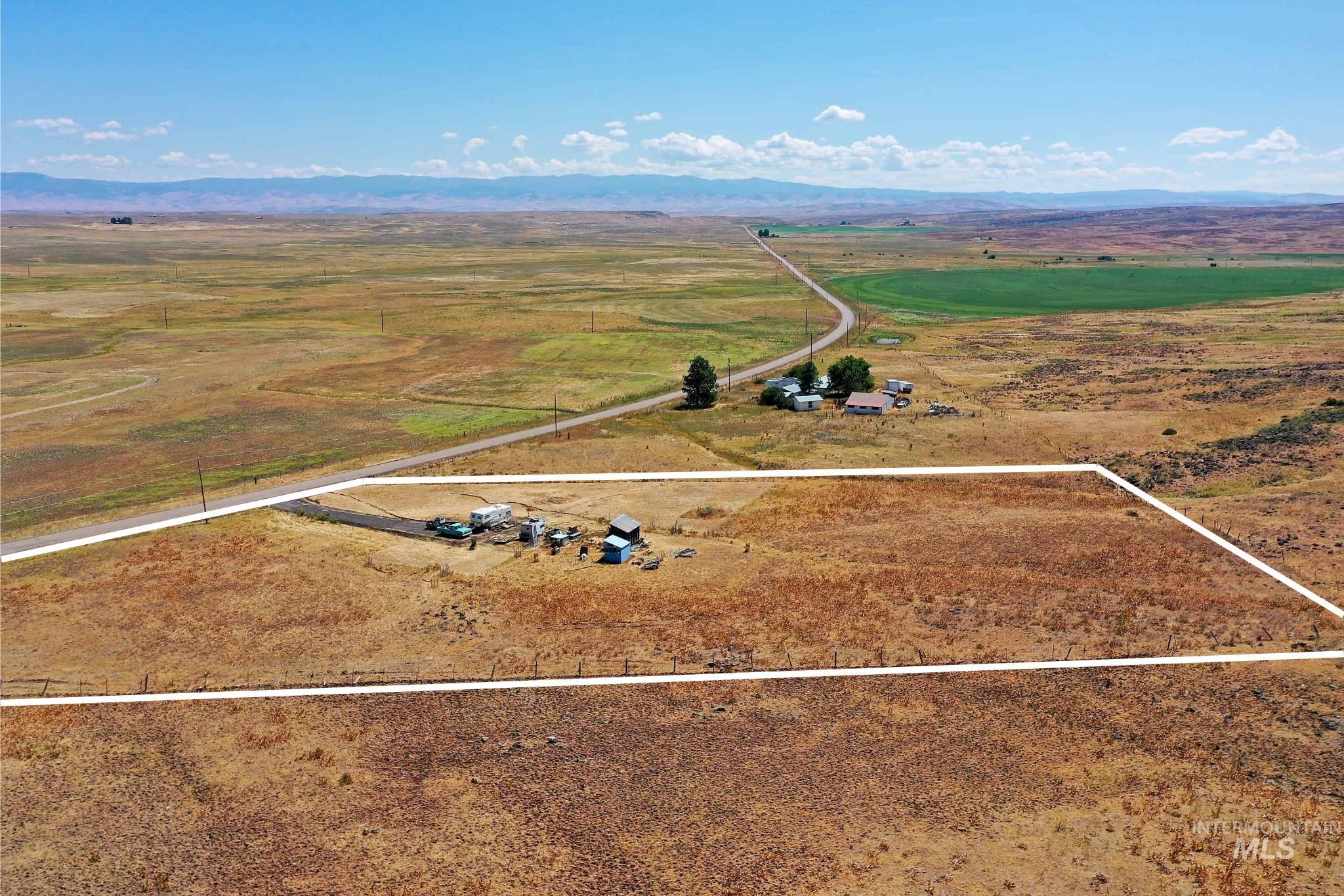 Overview of rural landscape with property boundaries highlighted and a mountainous background