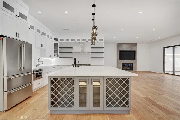 a kitchen with kitchen island stainless steel appliances a sink and a refrigerator
