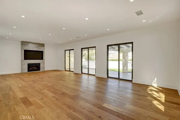 a view of empty room with wooden floor and fireplace