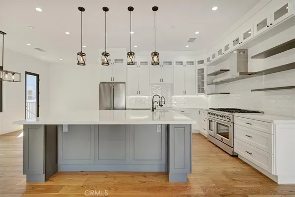 a kitchen with stainless steel appliances granite countertop a sink a stove and a refrigerator