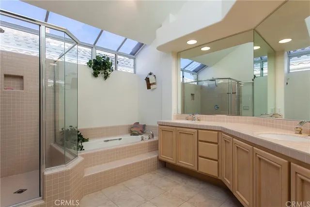 a spacious bathroom with a tub sink and mirror