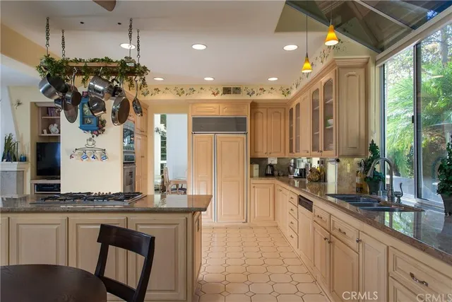 a large kitchen with granite countertop a large counter top sink and stainless steel appliances