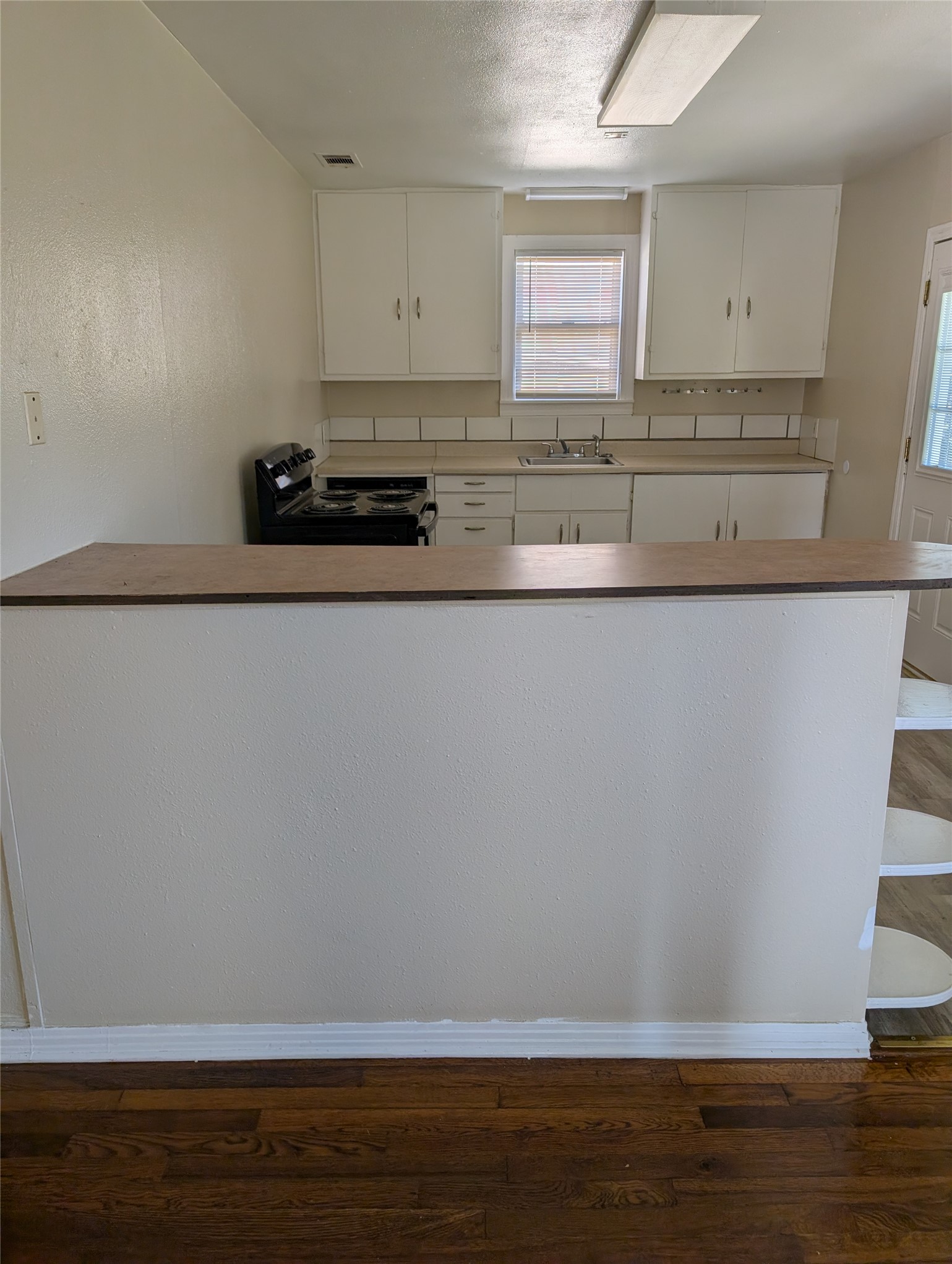 724 West 8th Street Taylor, TX 76574 - Photo 3 of 7 a view of cabinets and wooden floor