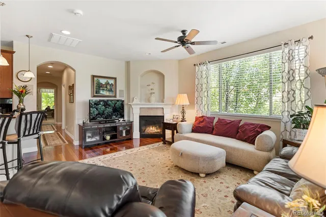 a living room with furniture ceiling fan and a fireplace