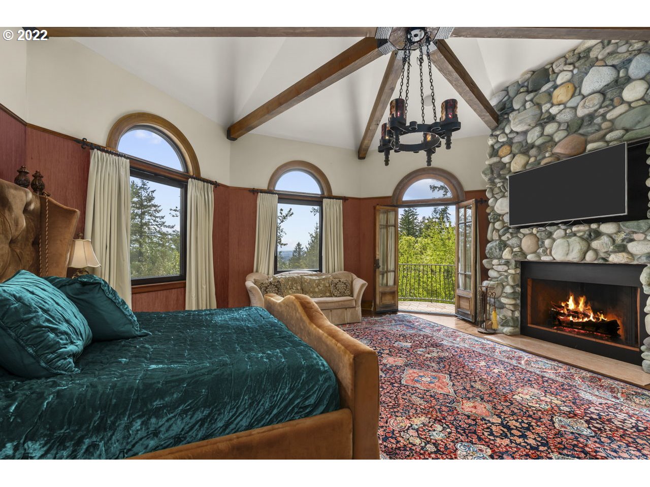 14125 Northwest Germantown Road Portland, OR 97231 - Photo 24 of 32 a bedroom with a bed a fireplace and a flat tv screen on the dresser