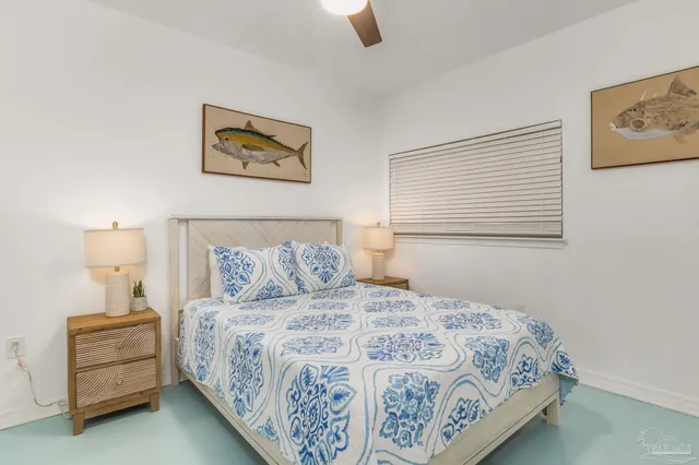 a bedroom with a bed and a lamp on dresser