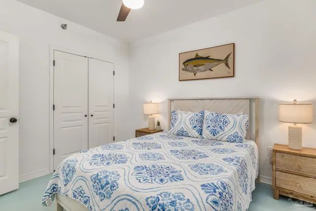 a bedroom with a bed and a lamp on dresser