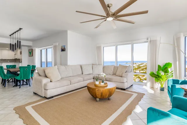 a living room with furniture a chandelier and a potted plant