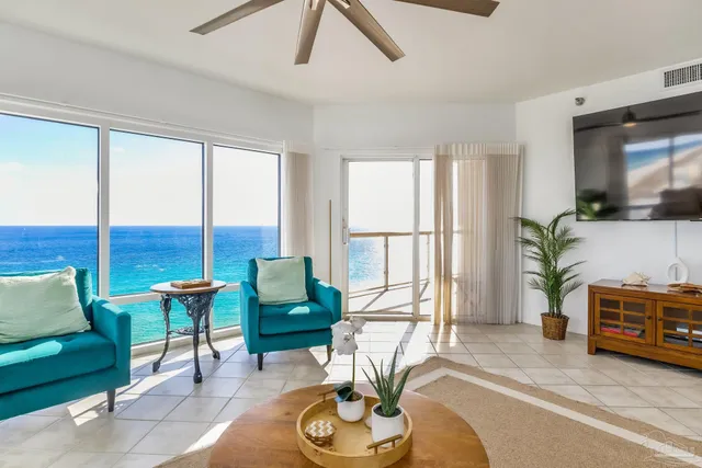 a living room with furniture and a floor to ceiling window